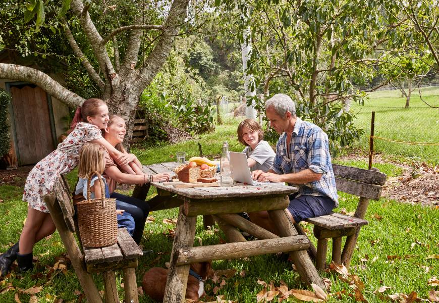 family-at-table-laptop-farm-picnic